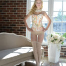 Wearing a knee-high off-white stockings, floral corset, and matching lace panty that adds a touch of elegance, Angelika D poses enticingly with so much finesse.