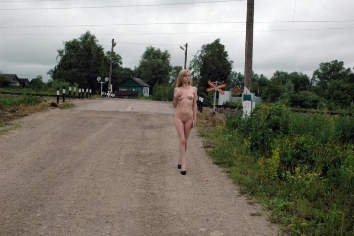 Young blonde with skinny body at railroad