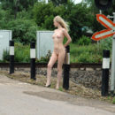 Young blonde with skinny body at railroad