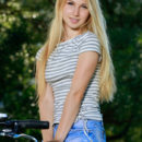 Kendell rides her bike outdoors as she bares her slender body and small pussy.