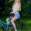 Kendell rides her bike outdoors as she bares her slender body and small pussy.