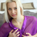 With a teasing smile, Leonie slowly removes her purple chiffon robe and periwinkle-colored panty, revealing her pink, puffy breasts and shaved pussy.