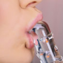 Vanda B has the look of sultry seductress as she lays naked on her bed holding her glass dildo.  Watch how this brunette beauty lubricates the dildo with her tongue and then slides it into her glistening pussy from behind.