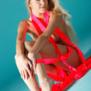 With bright pink strips of ribbons hugging her luscious body, Barbara D confidently poses for a studio shoot.