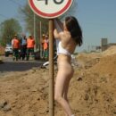 Young girl undresses in front of road workers