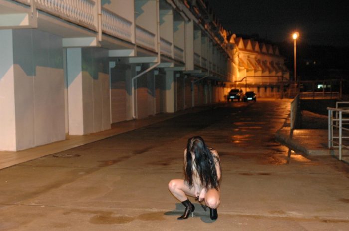 Brunette plays with remote vibrator at night promenade