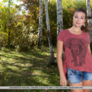 New model Aphrodesia strips in the forest baring ber sexy, tanned body.