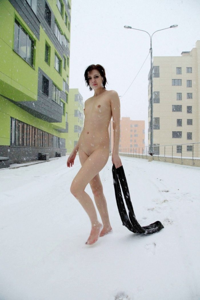 Short-haired bruneete walks naked at winter streets