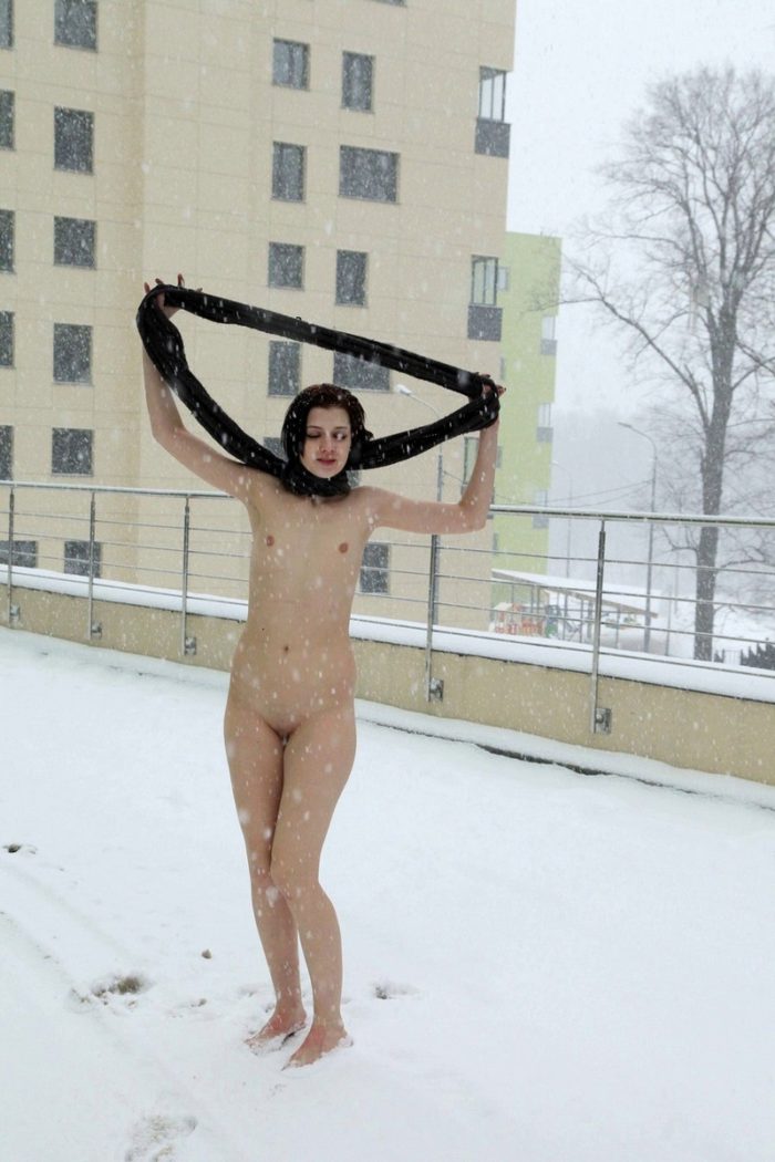 Short-haired bruneete walks naked at winter streets