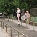 Two completely naked red-haired girls on city streets