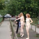 Two completely naked red-haired girls on city streets