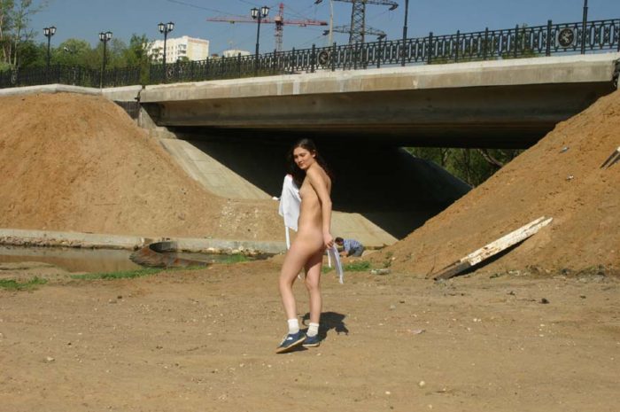 A young girl walks naked through the city streets