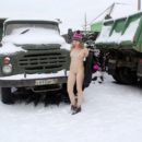 Blonde girl cleans snow from the truck