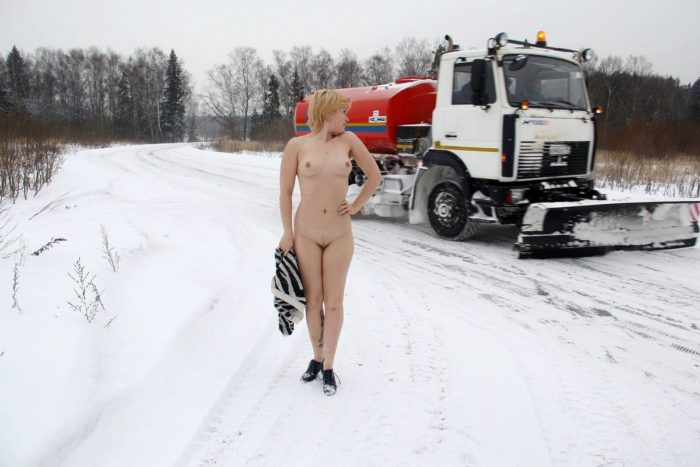 Blonde undresses on the side of the winter road