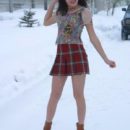 Brunette in leather boots on a snowy road