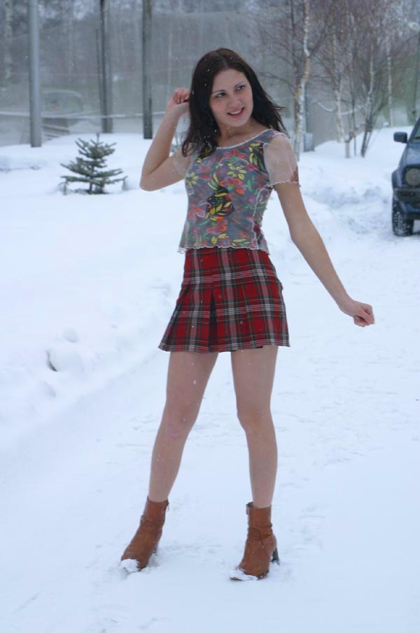 Brunette in leather boots on a snowy road