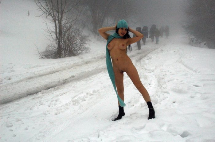 Girl without clothes meets hikers on a snowy road