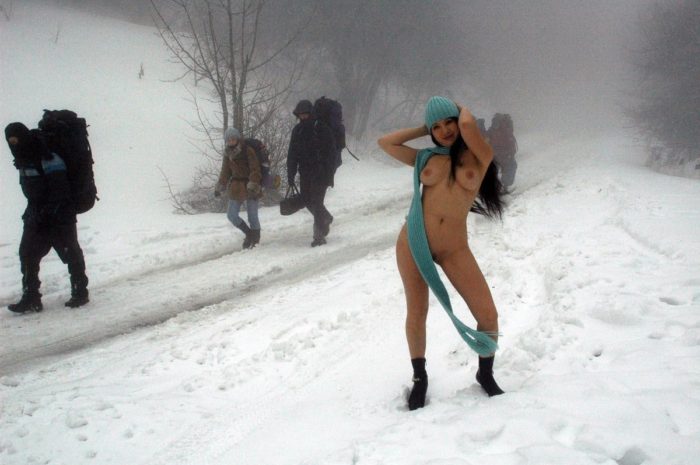 Girl without clothes meets hikers on a snowy road
