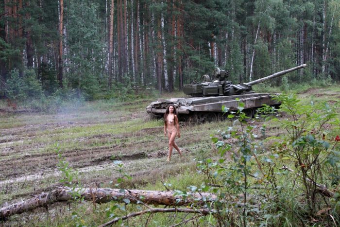 Long-haired russian girl posing at tank test site