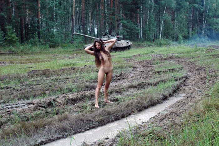 Long-haired russian girl posing at tank test site