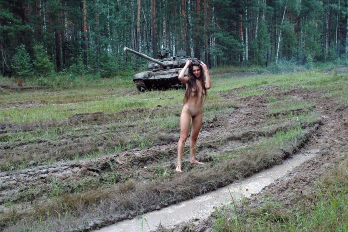 Long-haired russian girl posing at tank test site