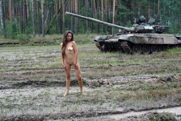 Long-haired russian girl posing at tank test site