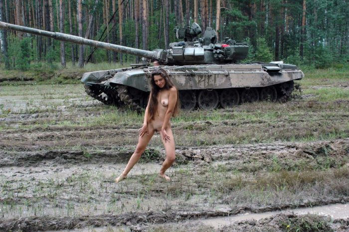 Long-haired russian girl posing at tank test site