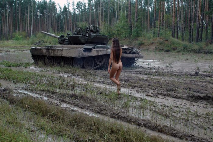 Long-haired russian girl posing at tank test site