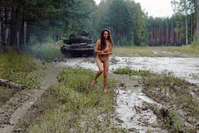 Long-haired russian girl posing at tank test site