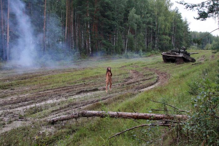 Long-haired russian girl posing at tank test site