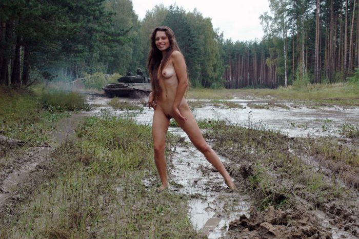 Long-haired russian girl posing at tank test site