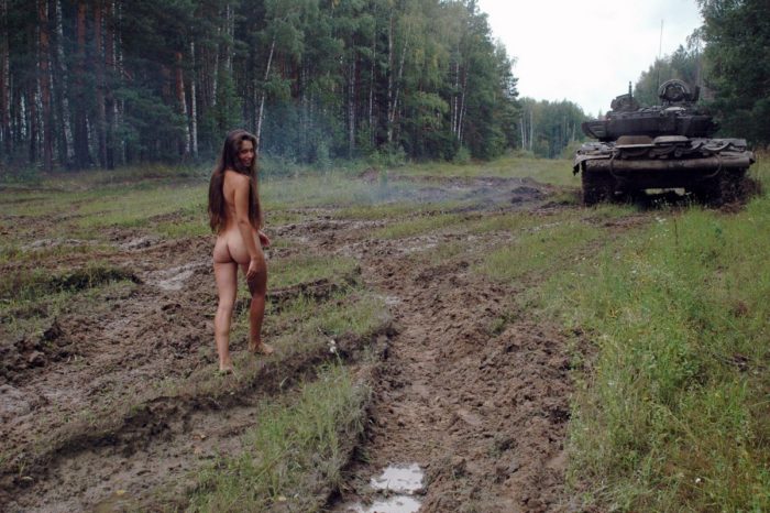 Long-haired russian girl posing at tank test site