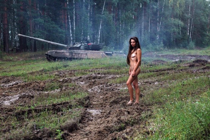 Long-haired russian girl posing at tank test site