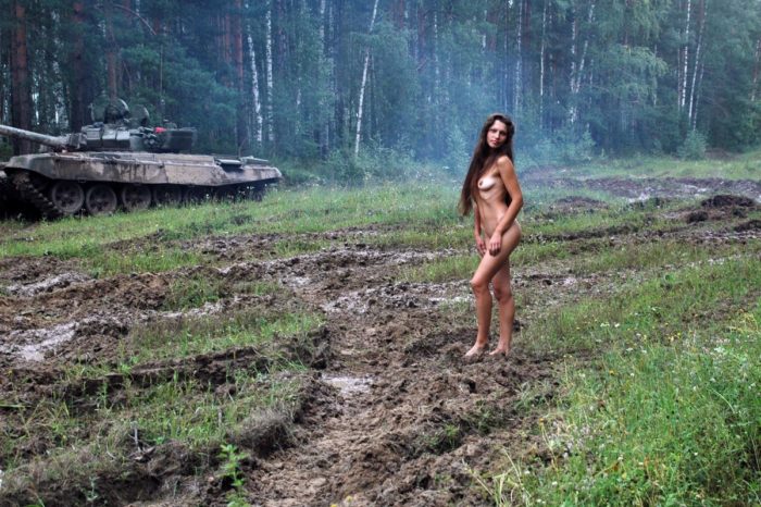 Long-haired russian girl posing at tank test site