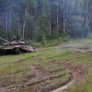 Long-haired russian girl posing at tank test site