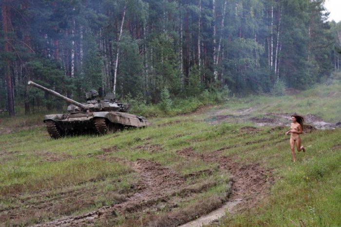 Long-haired russian girl posing at tank test site