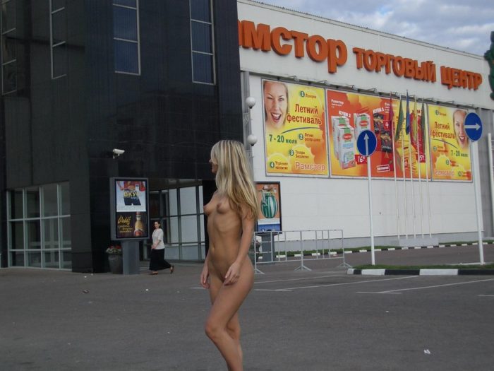 Naked blonde girl at the mall parking