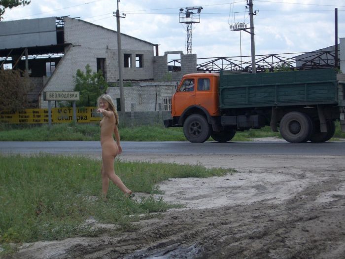 Naked blonde is photographed near a busy road