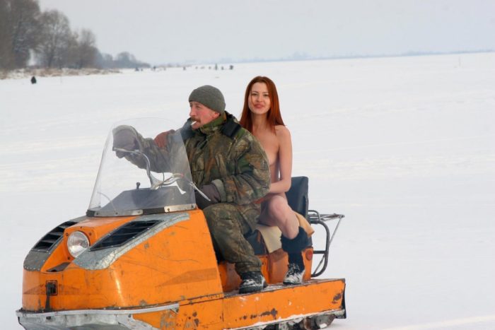 Naked girl riding a snowmobile