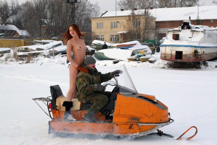 Naked girl riding a snowmobile