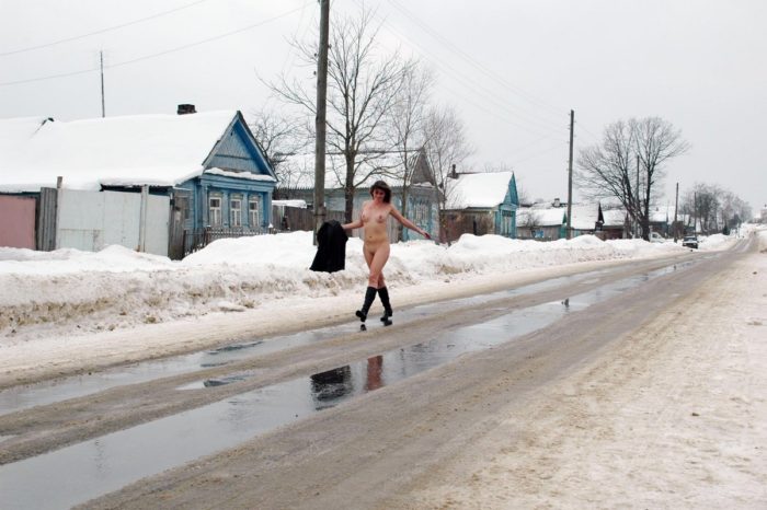 Naked girl walks on the winter road