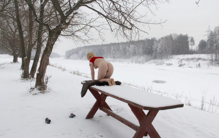 Short-haired blonde doing exercises on a snowy table