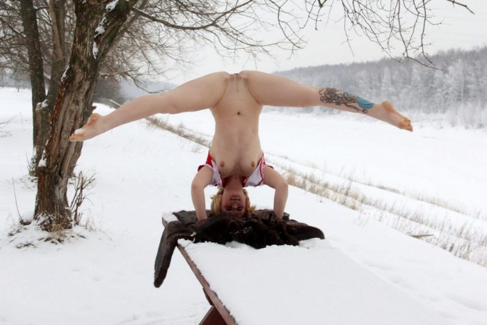 Short-haired blonde doing exercises on a snowy table