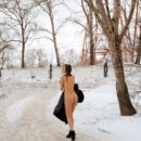 Smiling girl walks on winter streets in boots and mittens