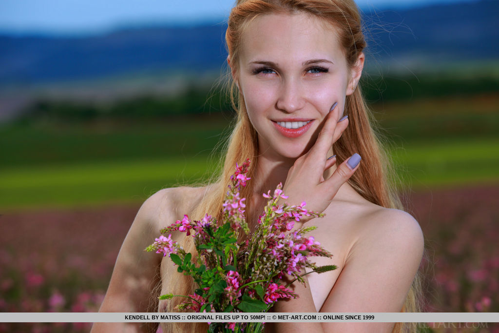 Kendell poses among the flowers baring her creamy, slender body.