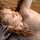 Sunny A displays her petite, nubile body as she sprawls on the sandy shore.