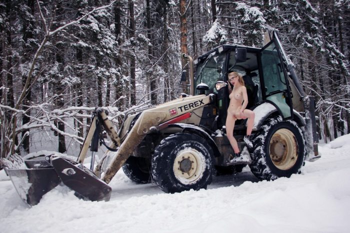 Naked Eva Gold posing on tractor