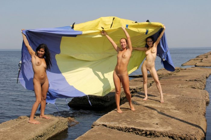 Three sexy sailors posing naked at stone pier