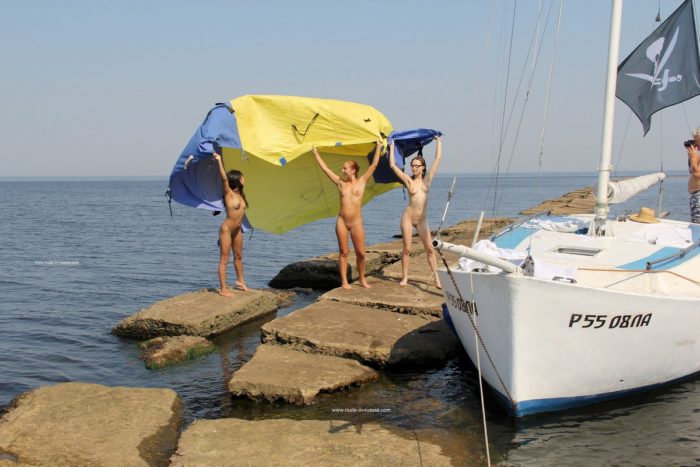 Three sexy sailors posing naked at stone pier