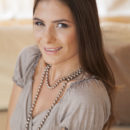 Csilla smiles sweetly as she strips off her clothes on top of the sofa